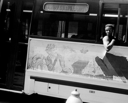 photo of a man on a bus leaning out of window