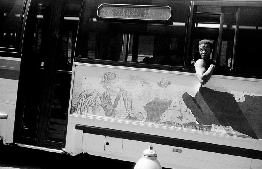 photo of a man on a bus leaning out of window