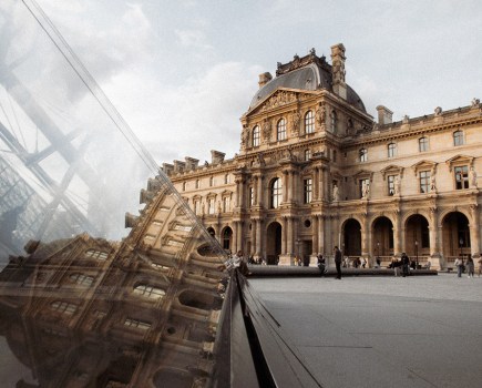 photo taken at louvre reflecting older building on glass