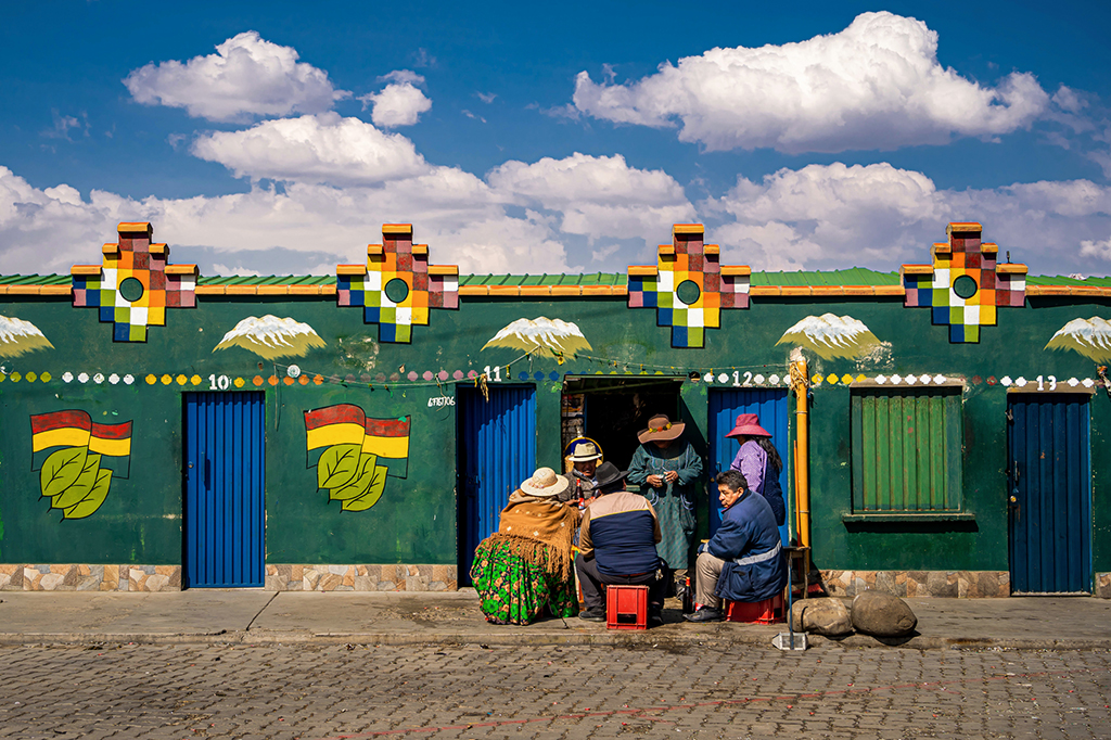 a group of shamans in La Paz, Bolivia, where they play a major role in Native Bolivian traditional culture, shot against the brightly painted local architecture