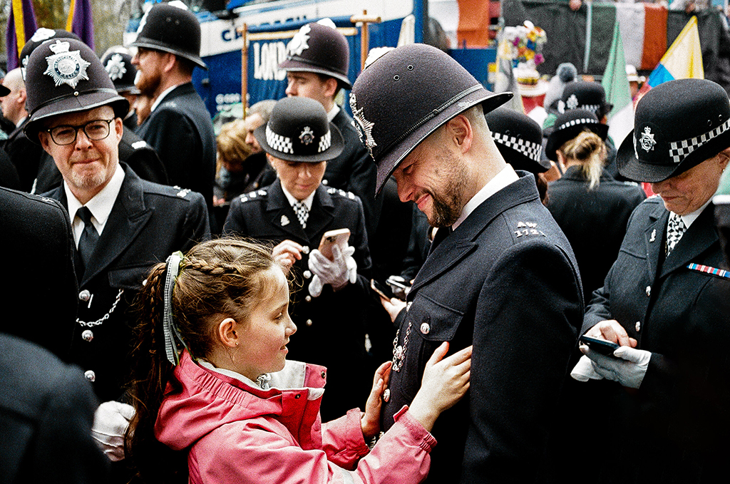 Police.
Camera: Konica Hexar AF
Film: 35mm, Kodak UltraMax / Portra 400 / ColourPlus. 
March 2024, St Patrick’s Day Parade at Green Park, London.
 little girl in pink talking to a policeman film photographer of the year winner