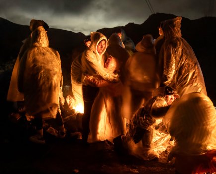 Chinese migrants warm themselves during a cold rain after crossing the US–Mexico border. Campo, California, 7 March 2024. Image: John Moore, Getty Images