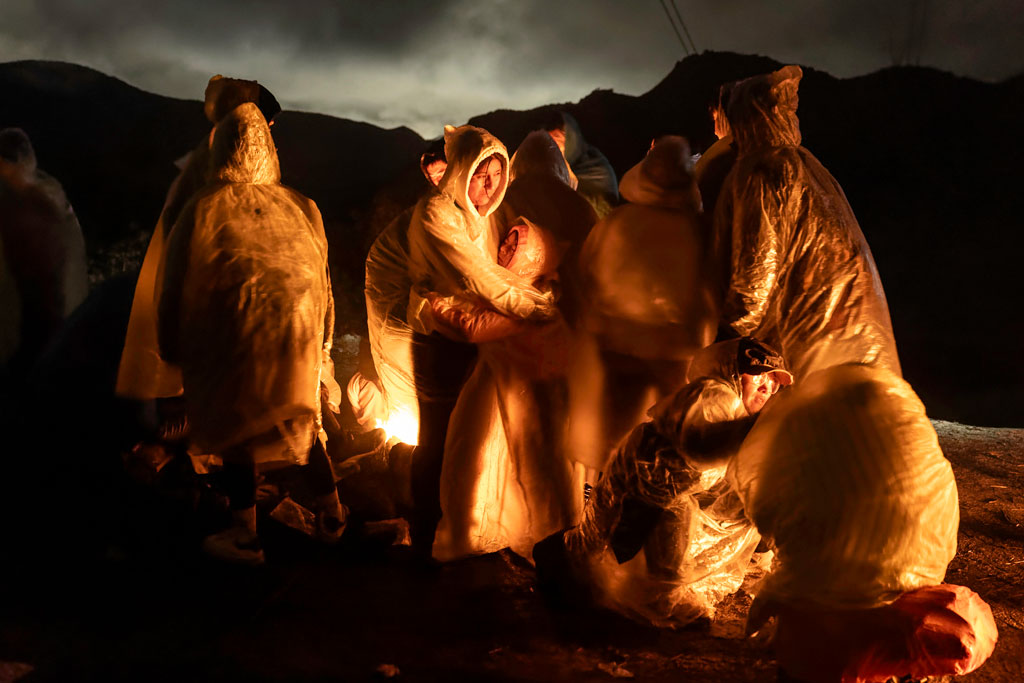 Chinese migrants warm themselves during a cold rain after crossing the US–Mexico border. Campo, California, 7 March 2024. Image: John Moore, Getty Images


