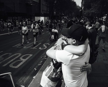 marathon runner hugging family member mid race
