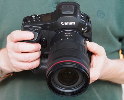 Canon EOS R1 full-frame mirrorless camera held in hand, with 24-70mm lens attached.