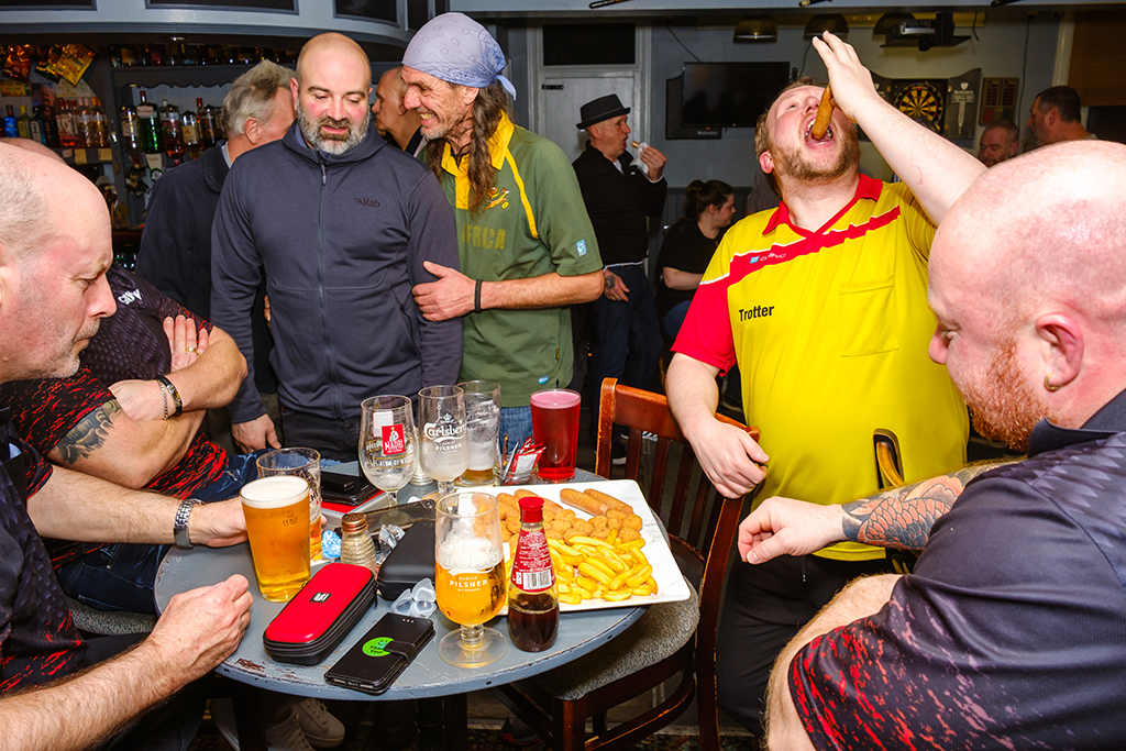 people in the pub eating sausages and chips
