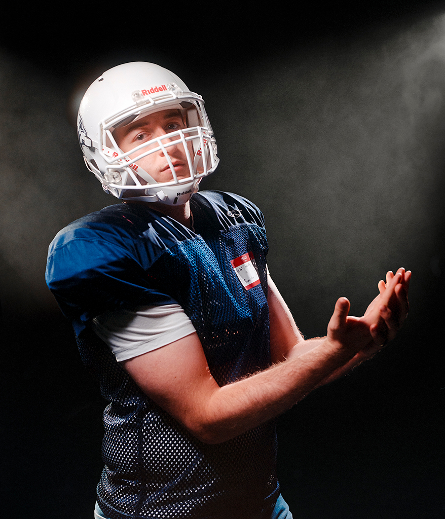 young man posing in american football gear