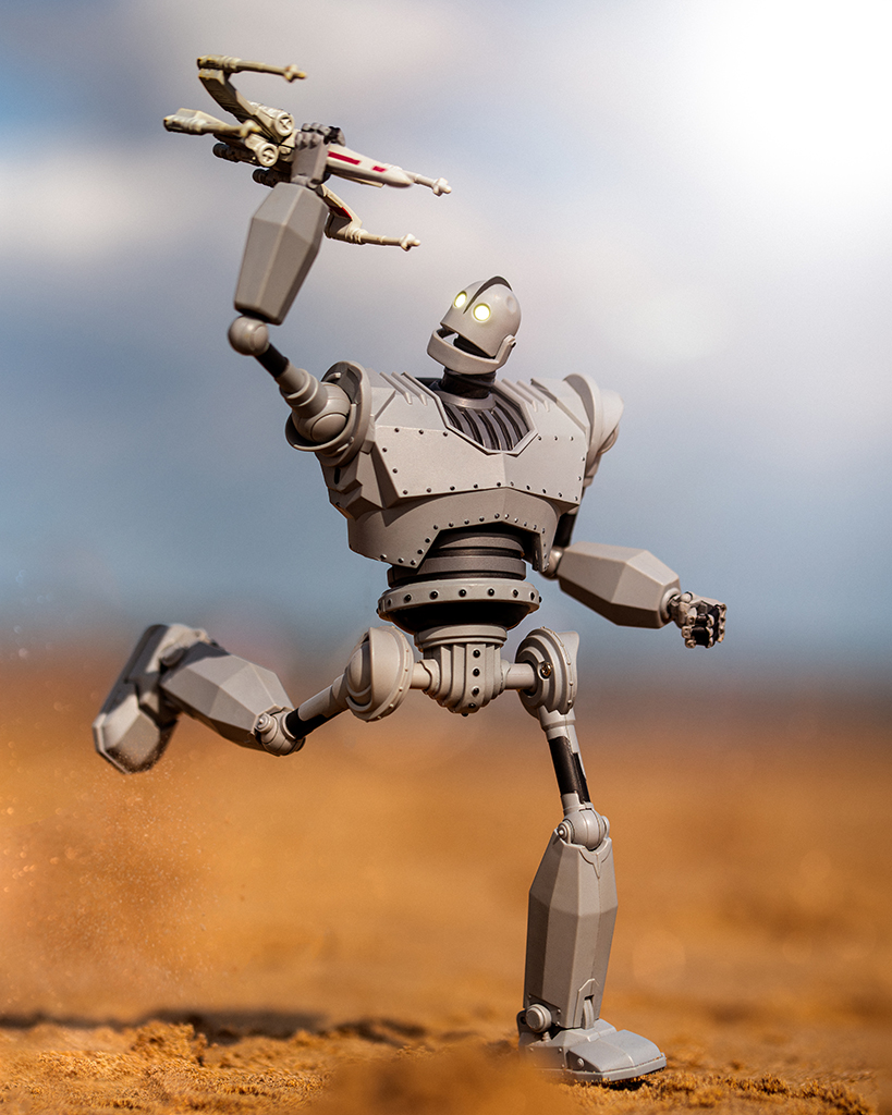 image of a running robot figurine holding another figurine with arm in the air