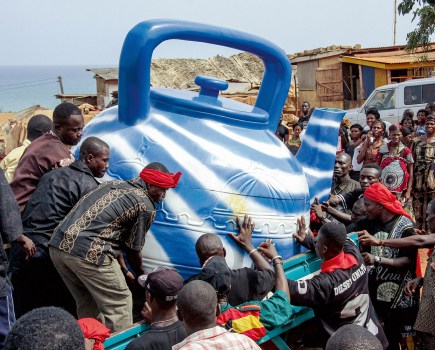 The family presents this fisherman and traditional priest with a coffin that corresponds to the blue teapot he used for his ritual ablutions. Central Region, 2009. (Coffin: Kudjoe Affutu). Image Credit: Regula Tschumi SINGLE USE ONLY