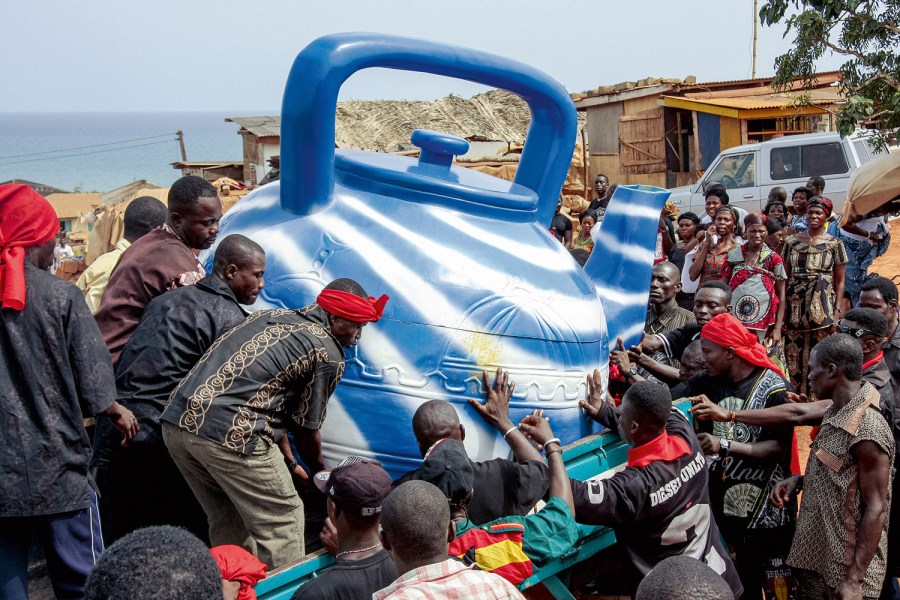 The family presents this fisherman and traditional priest with a coffin that corresponds to the blue teapot he used for his ritual ablutions. Central Region, 2009. (Coffin: Kudjoe Affutu). Image Credit: Regula Tschumi SINGLE USE ONLY