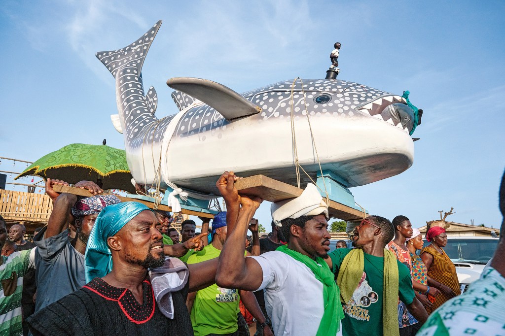 The family of the chief of the fishermen honours him with a whale shark. This is considered to be
the largest and strongest of the sharks, so such a coffin also symbolizes the high status of the
deceased. Greater Accra, 2024. (Coffin: Tawiah). Image Credit: Regula Tschumi SINGLE USE ONLY