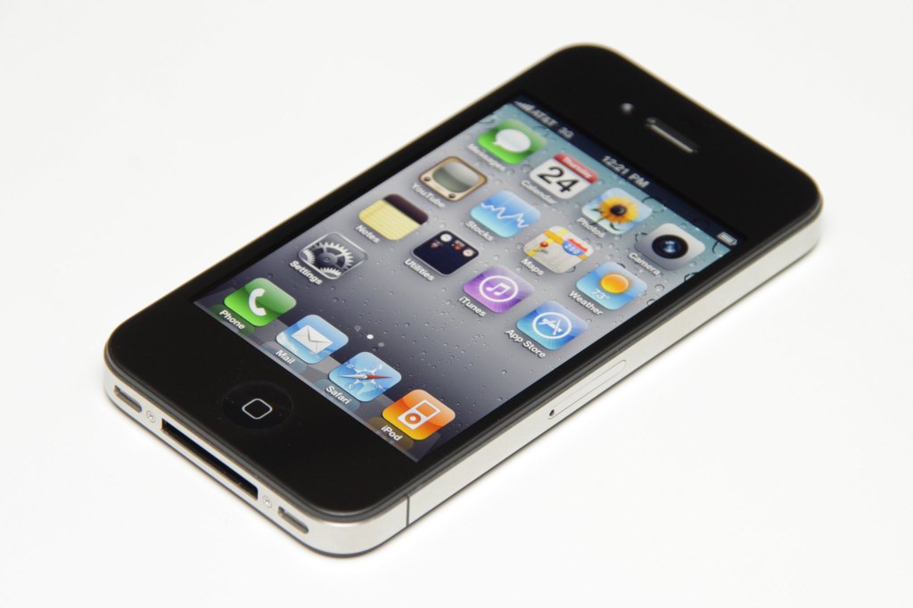 Photograph of iPhone 4 with home screen and apps visible