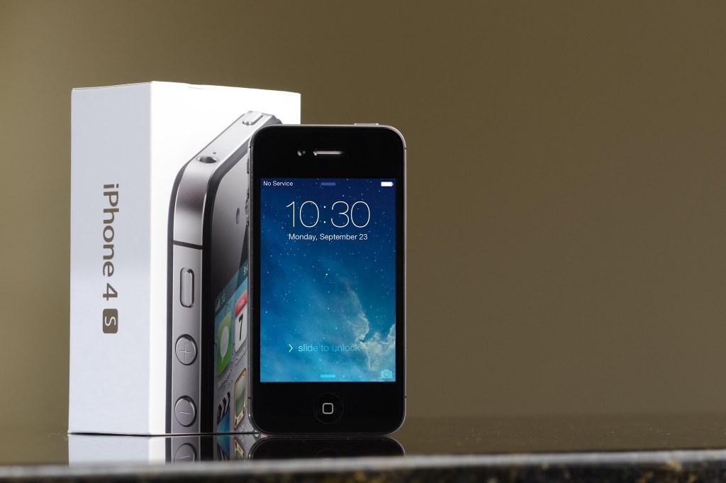 Photograph of iPhone 4s beside original box