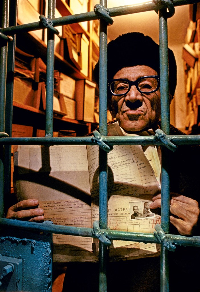 Azir Sandler in the entrance to his old cell, holding his original arrest papers from 50 years earlier. He remembers weighing 70 kilos when arrested, 42 kilos three months later. Image Credit: Barry Lewis SINGLE USE ONLY