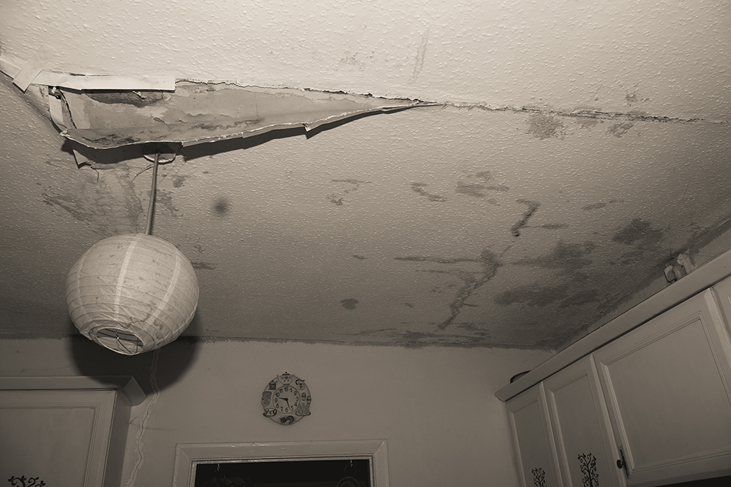 photo of a ceiling with peeling paint and large cracks