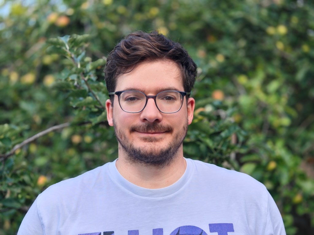 portrait of a man against green foliage