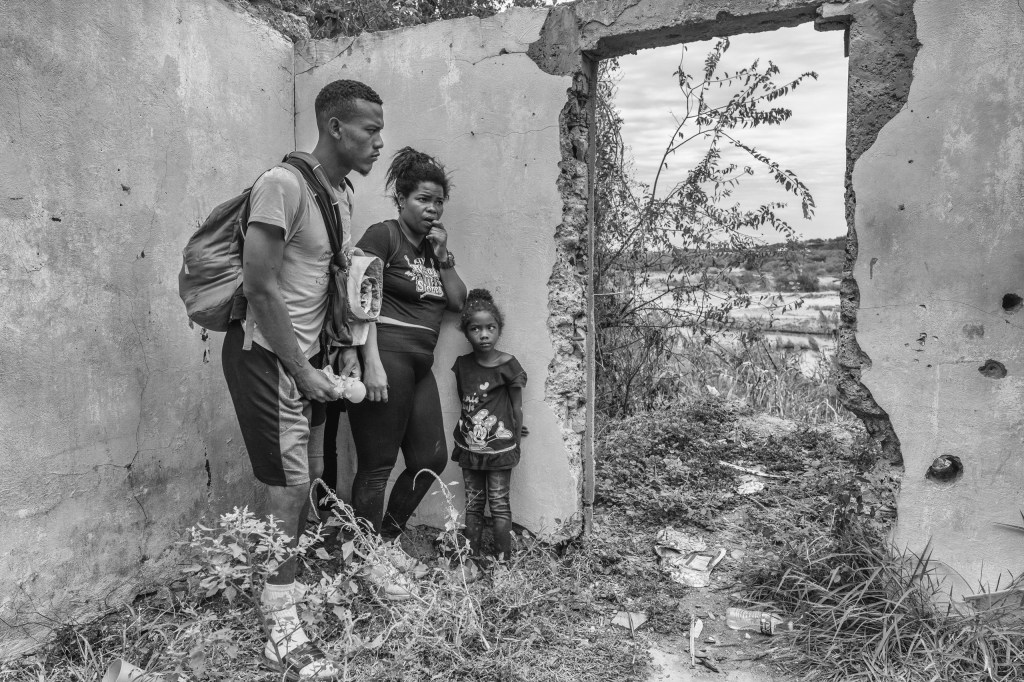 Eddie, Carolina and their four-year-old daughter Valentina, hide inside of an abandoned house before reaching the Rio Bravo in Piedras Negras, Mexico 2023. From the series “The Two Walls” © Alejandro Cegarra/LOBA 2025