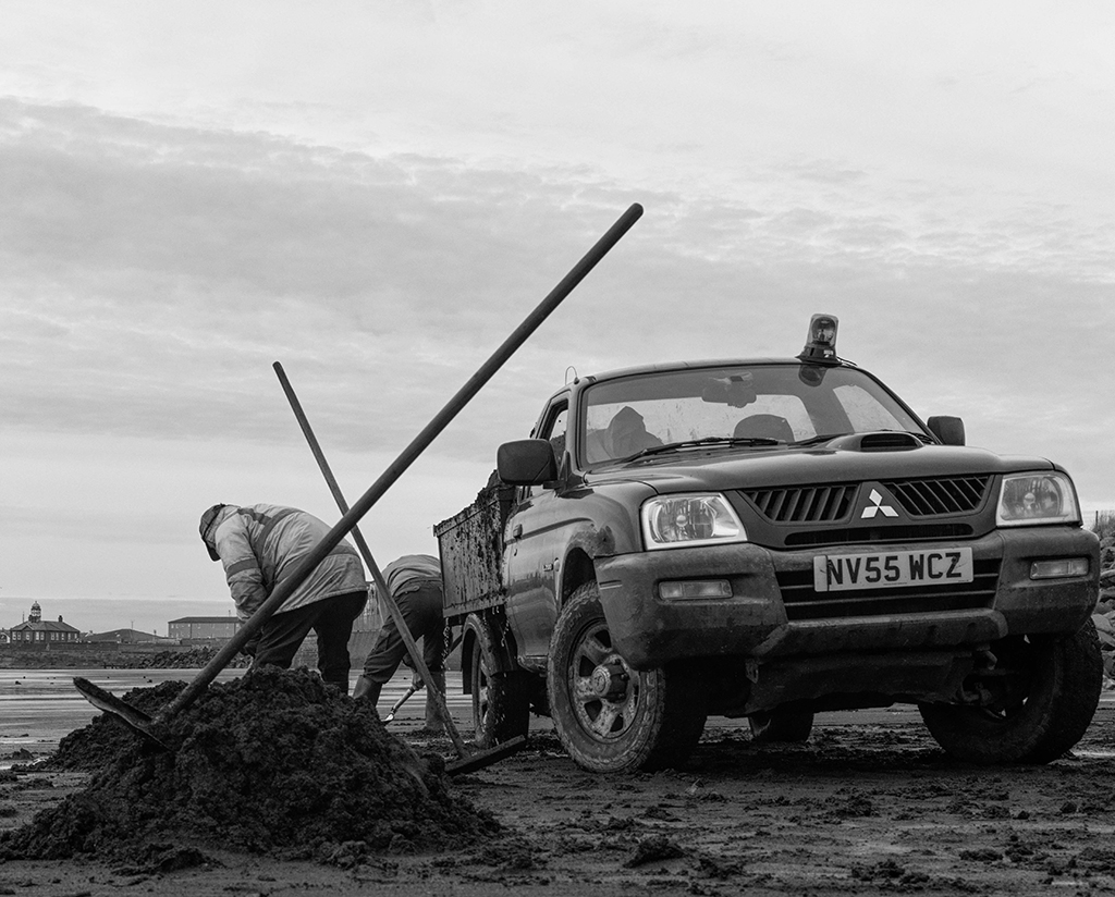 photo of man digging next to a truck