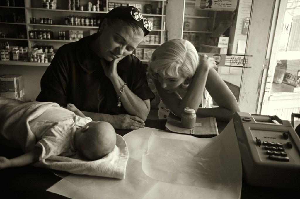 Marilyn Monroe with Paula Strasberg and a baby between takes filming The Misfits, Nevada, 1960 © The Estate of Eve Arnold