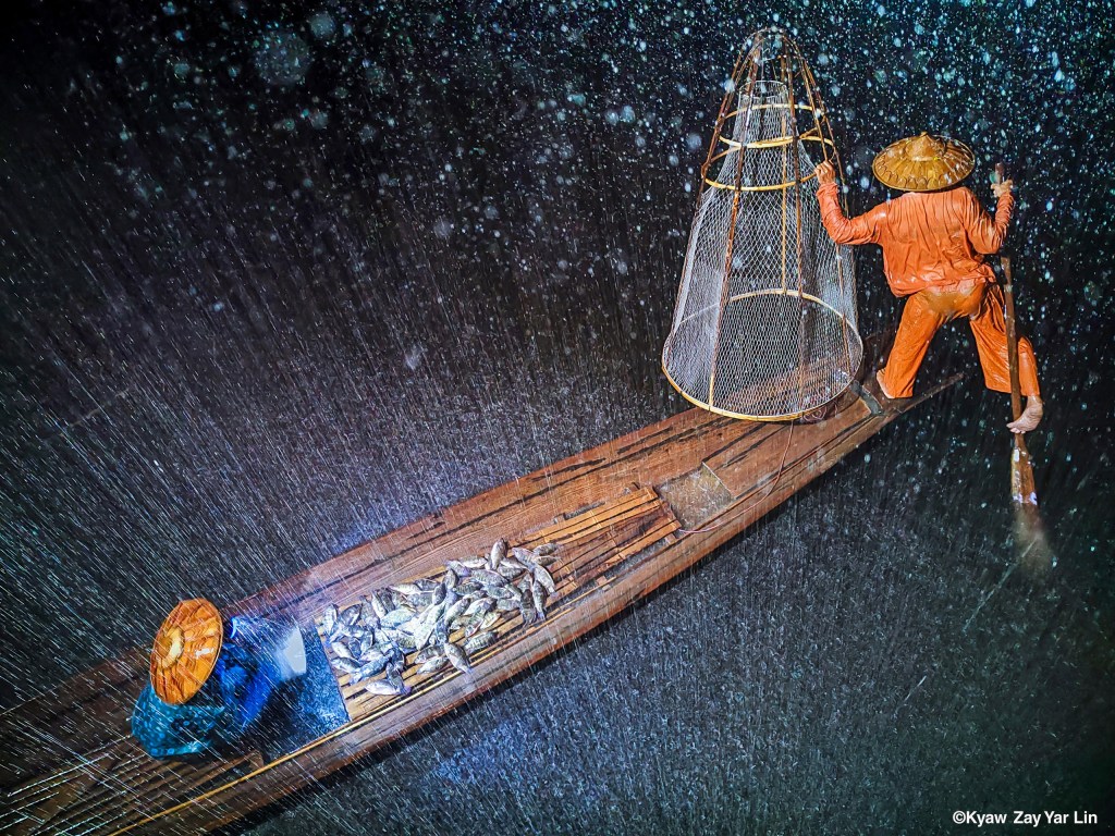 Fishing in raining season, by Kyaw Zay Yar Lin. Mobile Category, Winner. Standard Chartered Weather Photographer of the Year 2025