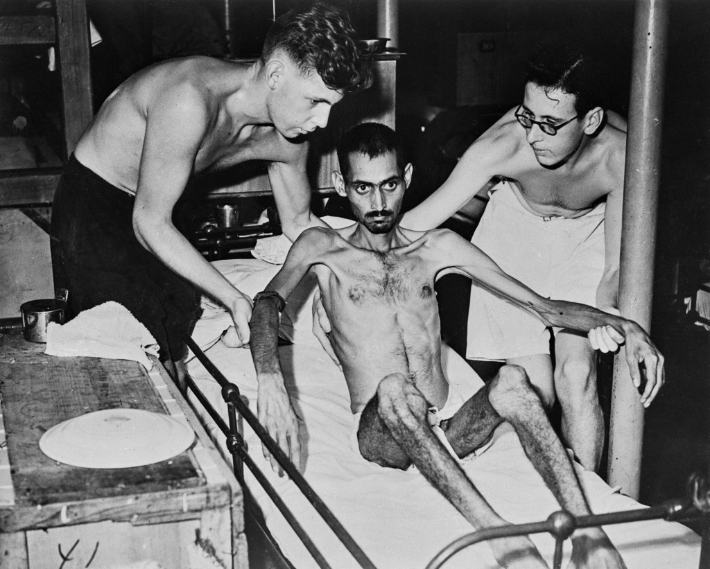 Sick Berth Attendant Hooson and Leading Sick Berth Attendant Mitchell supporting an Indian soldier aboard the HM Hospital Ship 'Oxfordshire' during the Second World War, circa 1945. The soldier, who had been brought out of Hong Kong, where he had been a prisoner of war, was suffering from malnutrition. (Photo by Fox Photos/Hulton Archive/Getty Images)