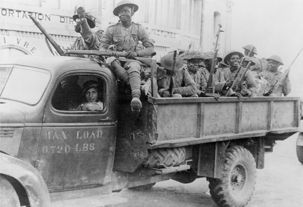 (Cheerful Askaris of the Kings African Rifles are riding through Tanarive, capital of Madagascar. Occupation of the capital gave meaning to complete British domination of the huge island. Much credit was due to the Askaris, many of whom were decorated for gallantry.