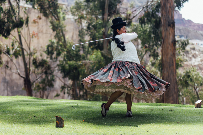 woman in pleated skirt golf swing