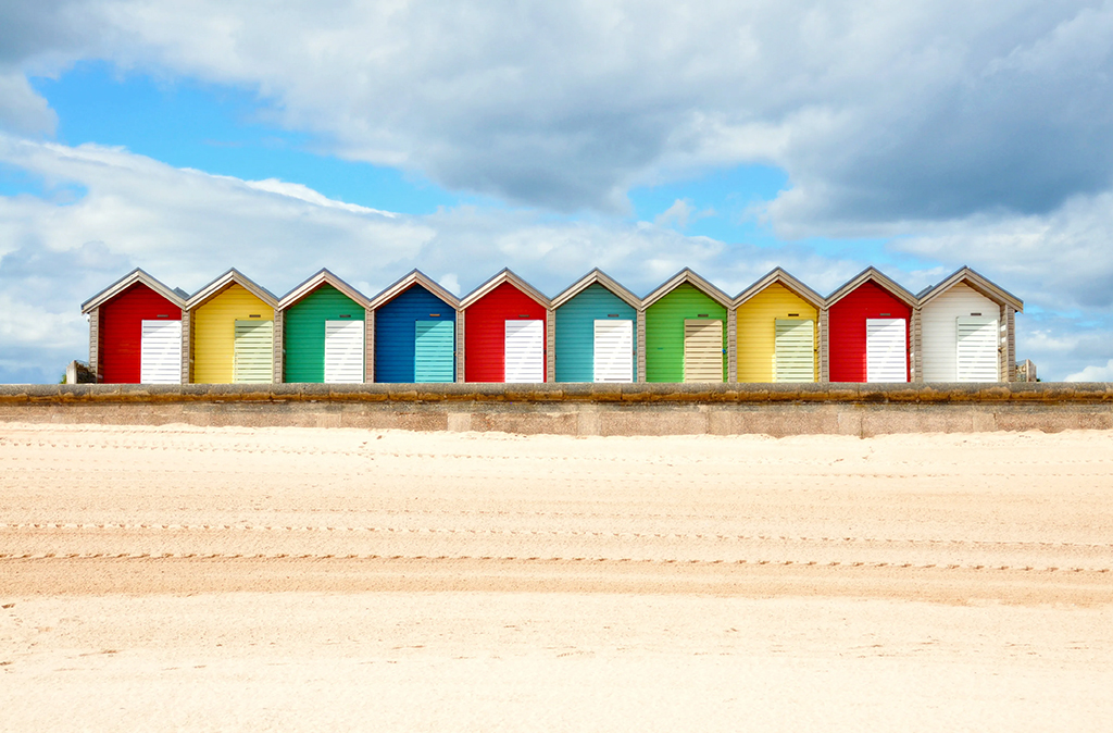 coloured beach houses along the sand