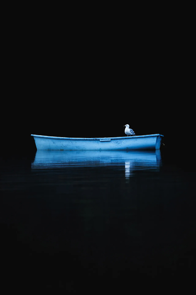 bright blue rowing boat against black background