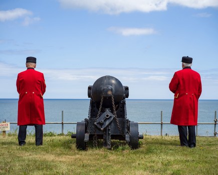 two men in red coat uniforms