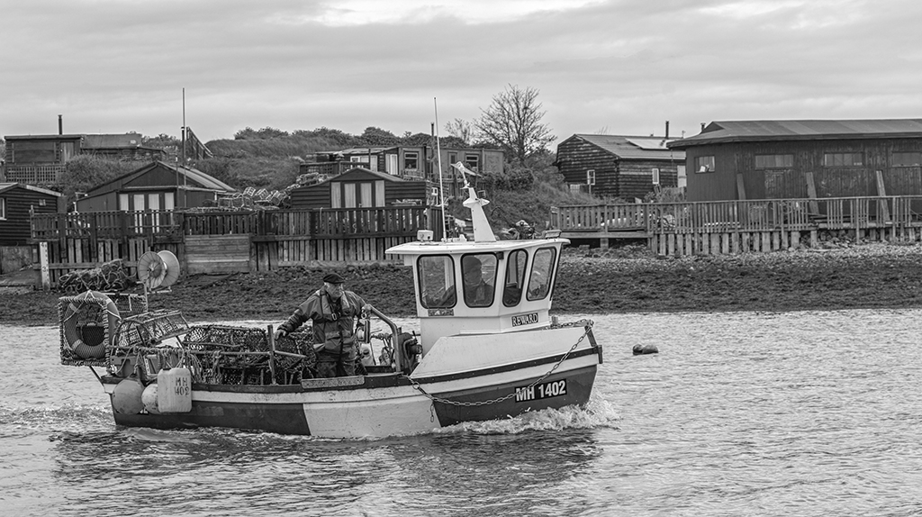 black and white image of a fishing boat taken from the water