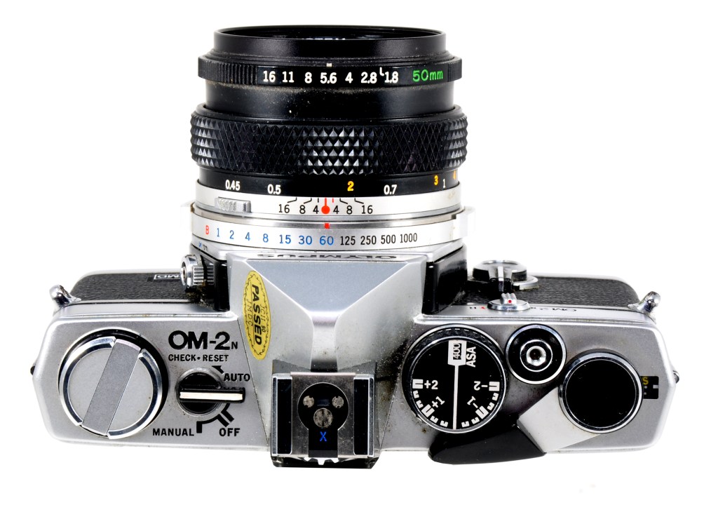 View from above showing the camera’s neatly-designed top plate and the usual Olympus style of shutter speed and aperture rings around the lens