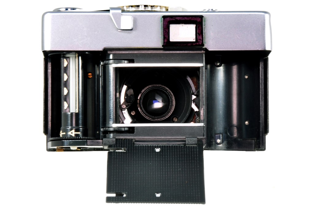 Inside the camera, showing a hinged plate that folds up over the film once loaded