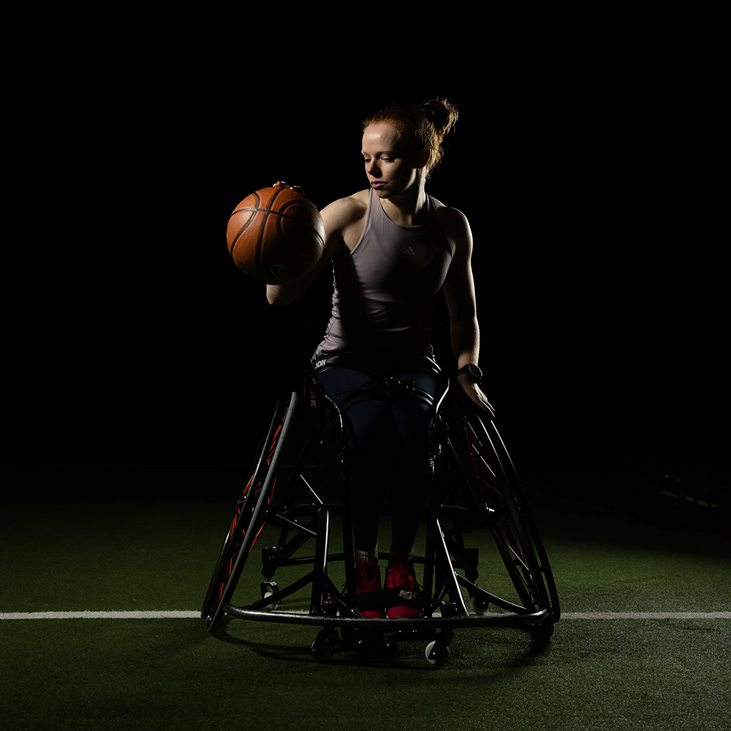 low light portrait of a girl in a wheelchair with basketball