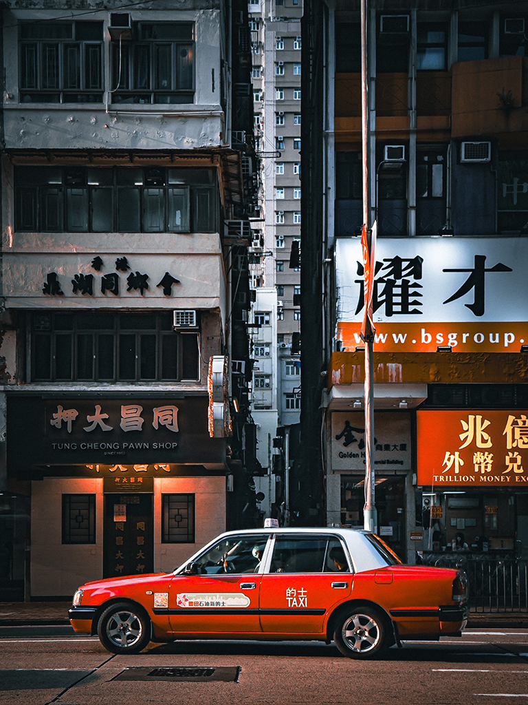 red taxi in front of street buildings