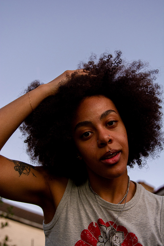 portrait of a girl with a hand in her afro