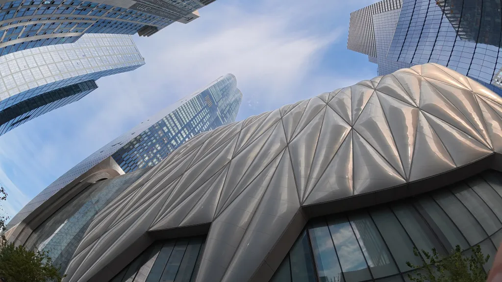 Sample image from DJI Osmo Action 6, showing upward view of tall buildings with pronounced distortion