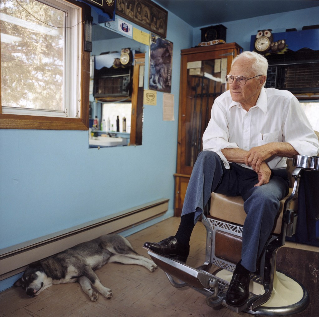 Gilbert Jones, the only barber for 100 miles, recalled plagues of locusts and no power, Faith, South Dakota, USA. Image Credit: Peter Dench