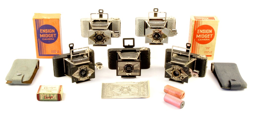 The full range of Ensign Midget cameras with boxes, cases, instruction book and E10 film