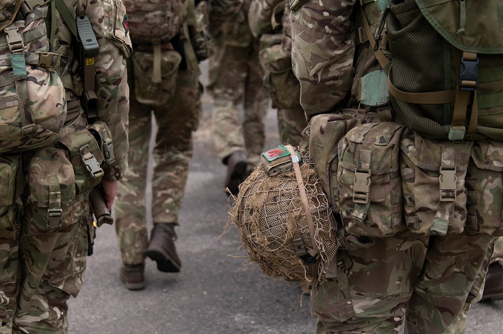 close up of soldier carrying  camoflage helmet