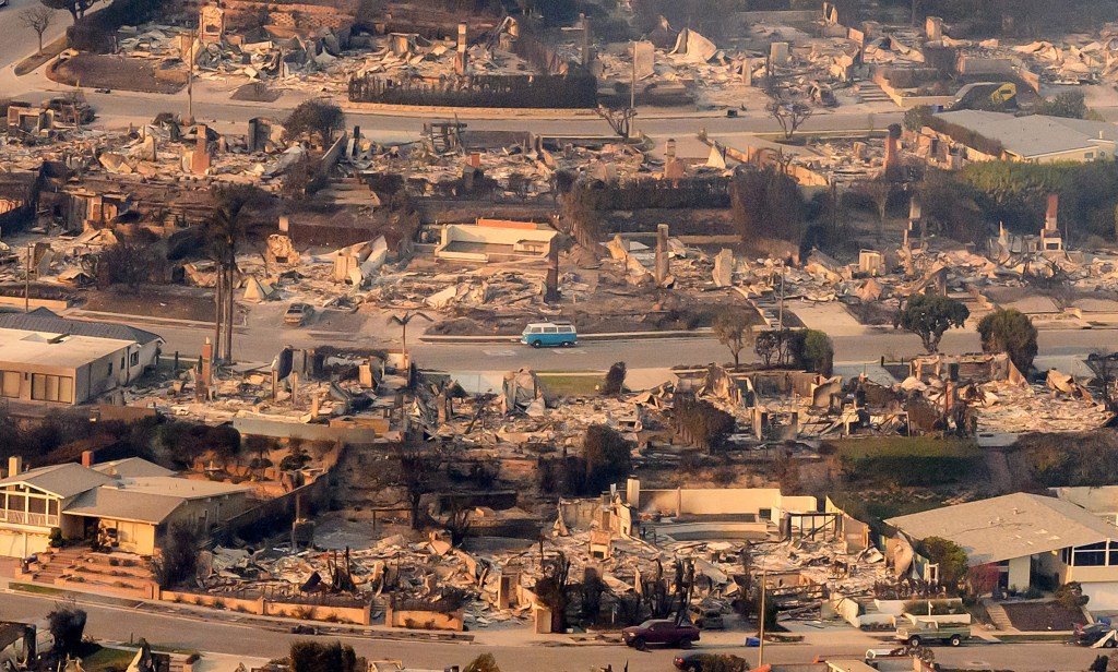 View – taken from a helicopter – of a blue van intact amid burned homes seen from above during the Palisades
fire near the Pacific Palisades neighbourhood of Los Angeles, California on January 9, 2025. Swaths of the United States’ second-largest city lay in ruins, with smoke blanketing the sky and an acrid smell pervading almost every building. Image Credit Josh Edelson/AFP via Getty Images