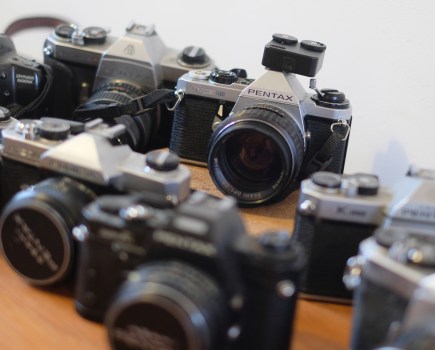 Photograph of several vintage SLR cameras, one of which has the TTArtisan light meter in its hotshoe