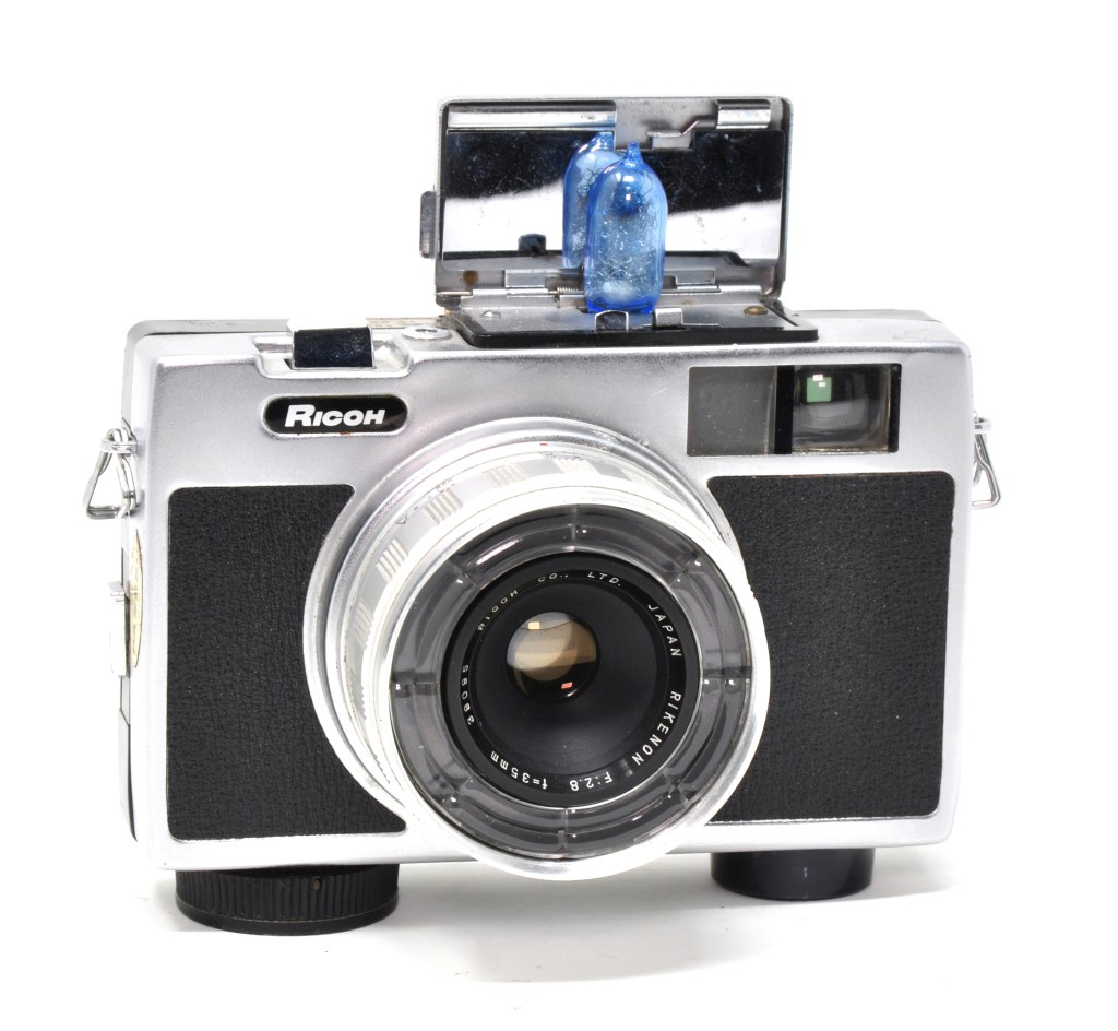 The Ricoh Auto 126 with AG-1 flashbulb fitted, a 126 cartridge film camera with clockwork motor drive