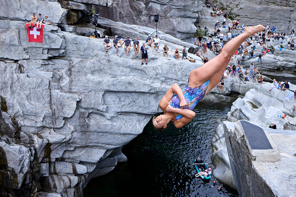 person diving off a cliff