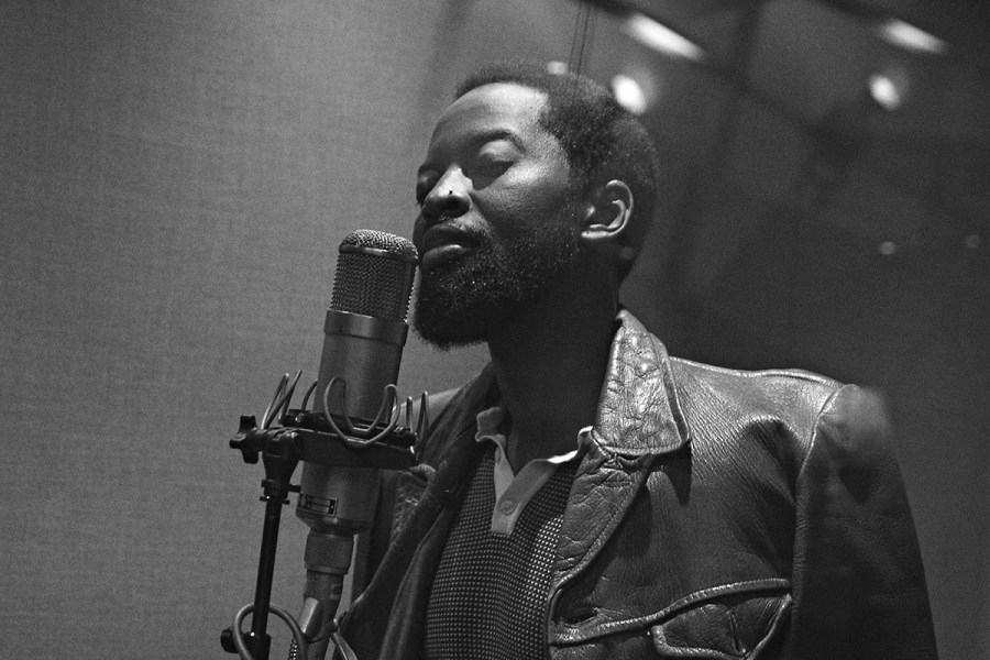 portrait of a man stood next to microphone in studio