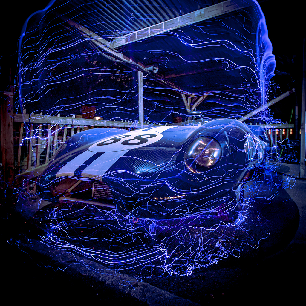blue car with white strike down the middle with fibre-optic light whip effect around it