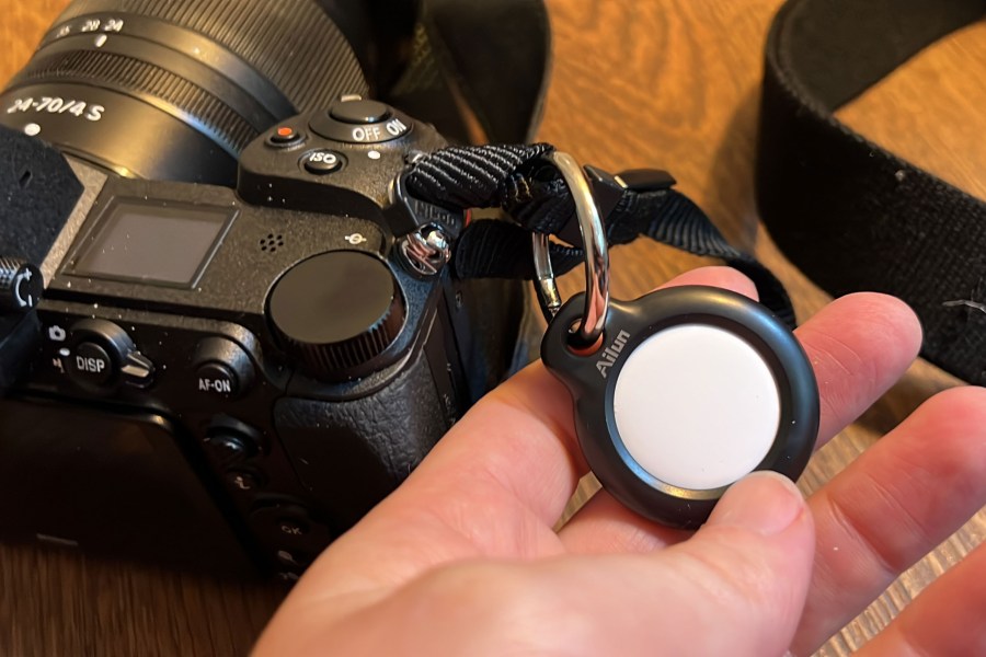 An AirTag attached to a Nikon camera