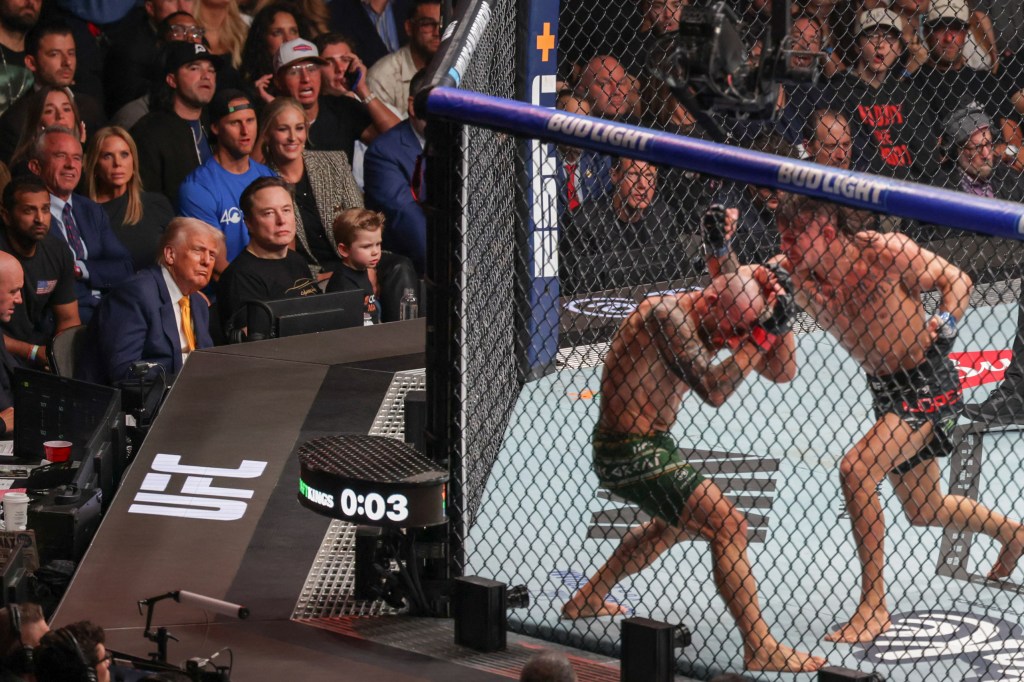 MIAMI, FLORIDA - APRIL 12: U.S. President Donald Trump, along with (L-R behind him) FBI Director Kash Patel and Robert F. Kennedy, Jr., Secretary of the U.S. Department of Health and Human Services, Elon Musk and his son (seated to Trump's right), watch Australian fighter Alexander Volkanovski and Brazilian fighter Diego Lopes during an Ultimate Fighting Championship fight at the Kaseya Center on April 12, 2025 in Miami, Florida. The Trump administration issued a rule late Friday that spared smartphones, computers, semiconductors, and other electronics from some of the tariffs they have enacted. (Photo by Joe Raedle/Getty Images)
