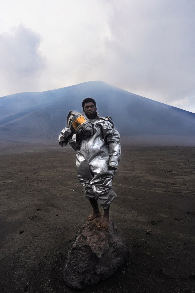 volcano scientist standing atop a volcanic rock bomb on the island of Tanna, Vanuatu