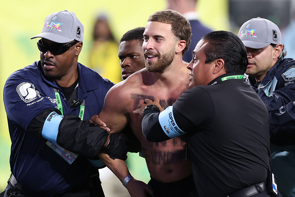 SANTA CLARA, CALIFORNIA - FEBRUARY 08: A fan who ran on the field during the fourth quarter is escorted out of the stadium in Super Bowl LX between the Seattle Seahawks and the New England Patriots at Levi's Stadium on February 08, 2026 in Santa Clara, California. (Photo by Kevin C. Cox/Getty Images)